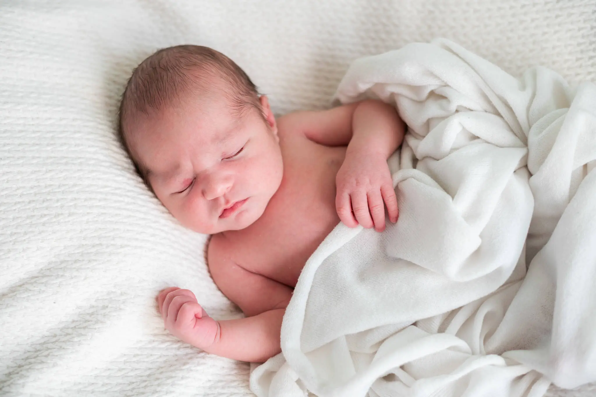 Photo d'un bébé allongé lors de sa séance photo de naissance