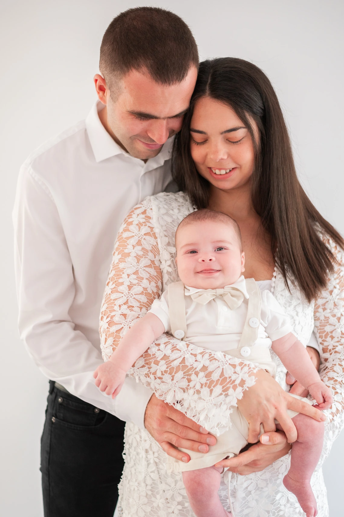 Portrait de famille de deux parents et leur bébé de 4 mois, lors de leur séance photo en famille à domicile en Seine et Marne