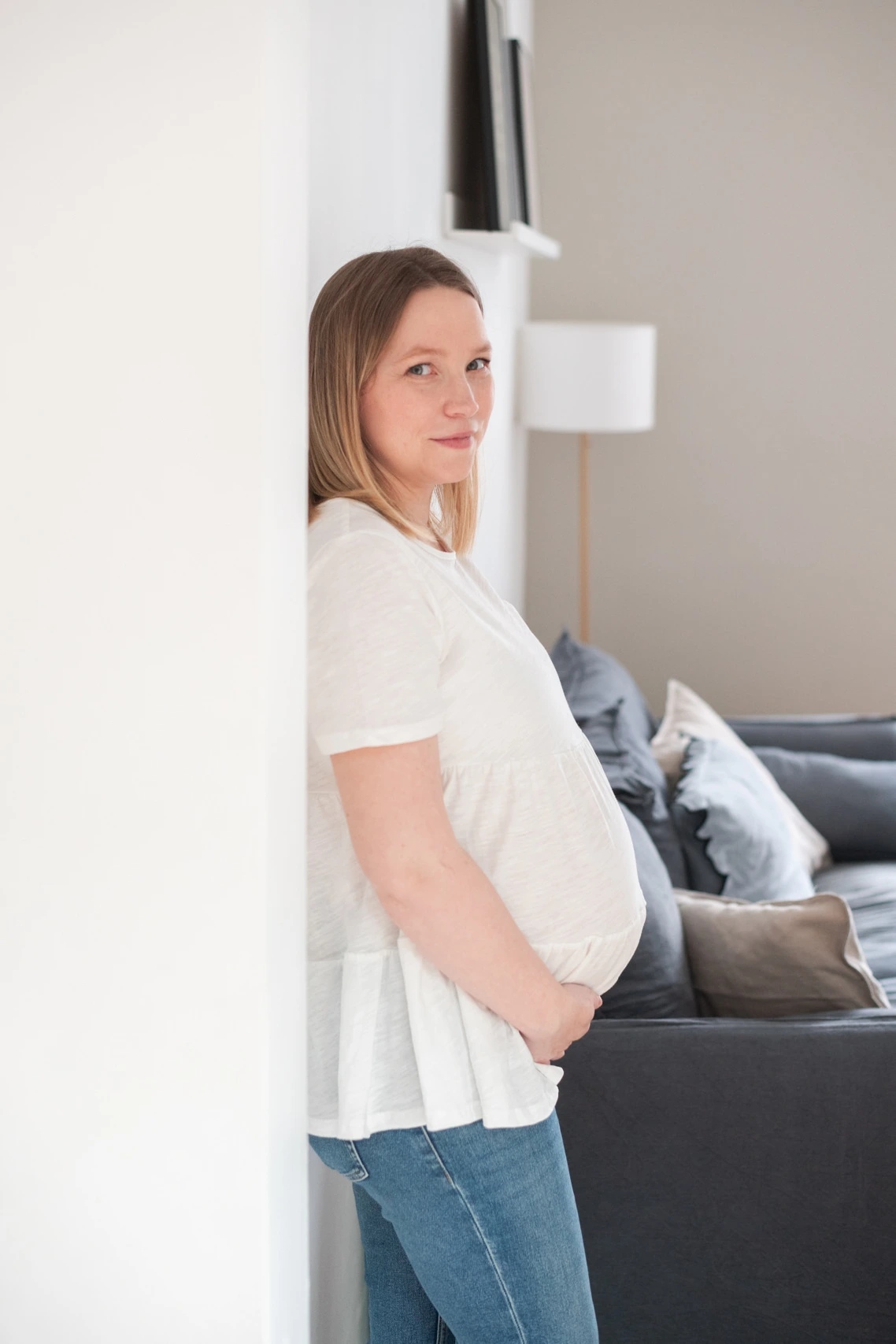 Femme enceinte de jumeaux lors d'une séance photo de grossesse à domicile, dans son salon près de Fontainebleau