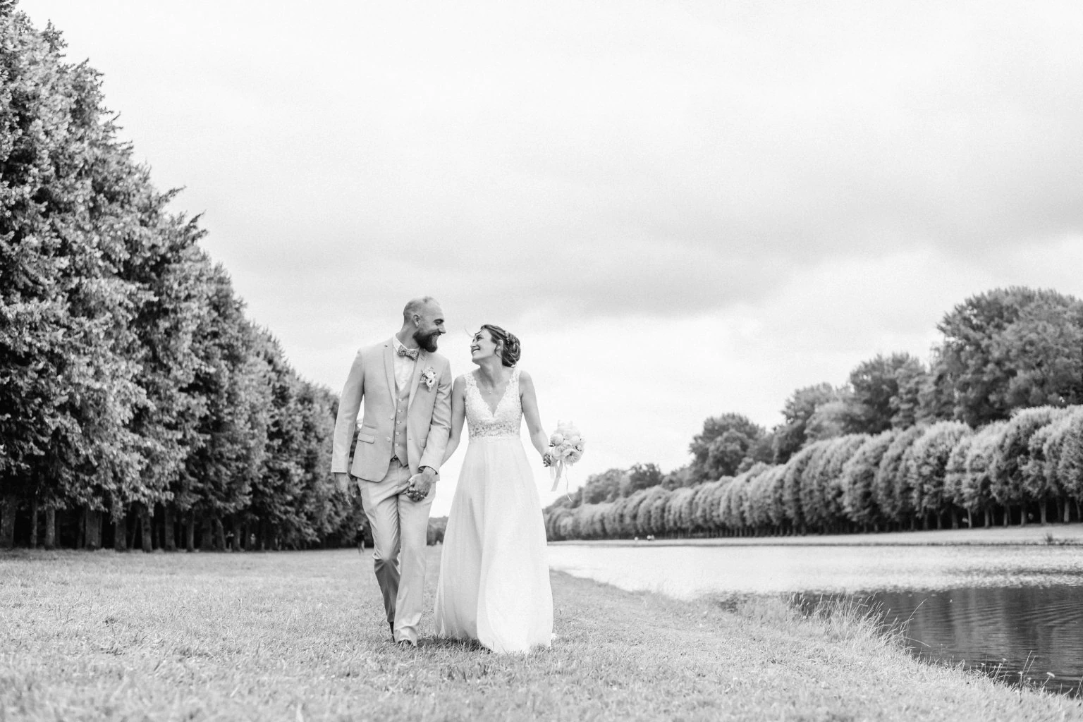 Photo d'un couple de mariés lors de leur séance photo de mariage réalisé près du canal des jardins du Château de Fontainebleau