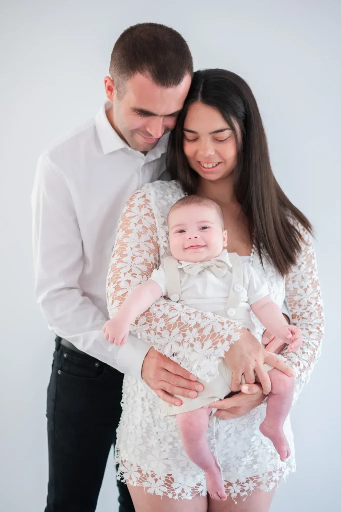 Moment de douceur et câlin en famille entre un papa, une maman et leur bébé lors d'une séance photo en famille à leur domicile en Seine et Marne