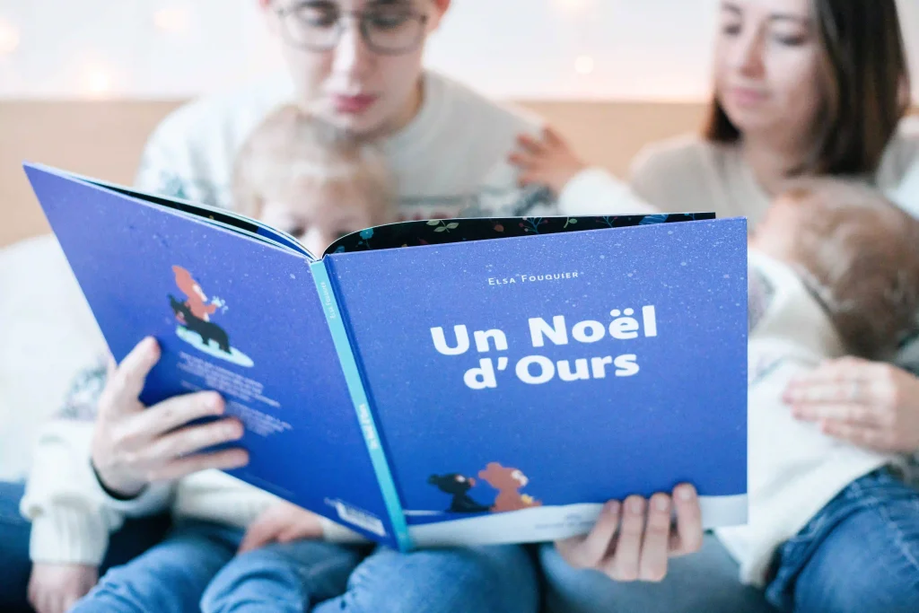 Famille qui lit une histoire de Noël lors d'une séance photo en famille à domicile à Fontainebleau