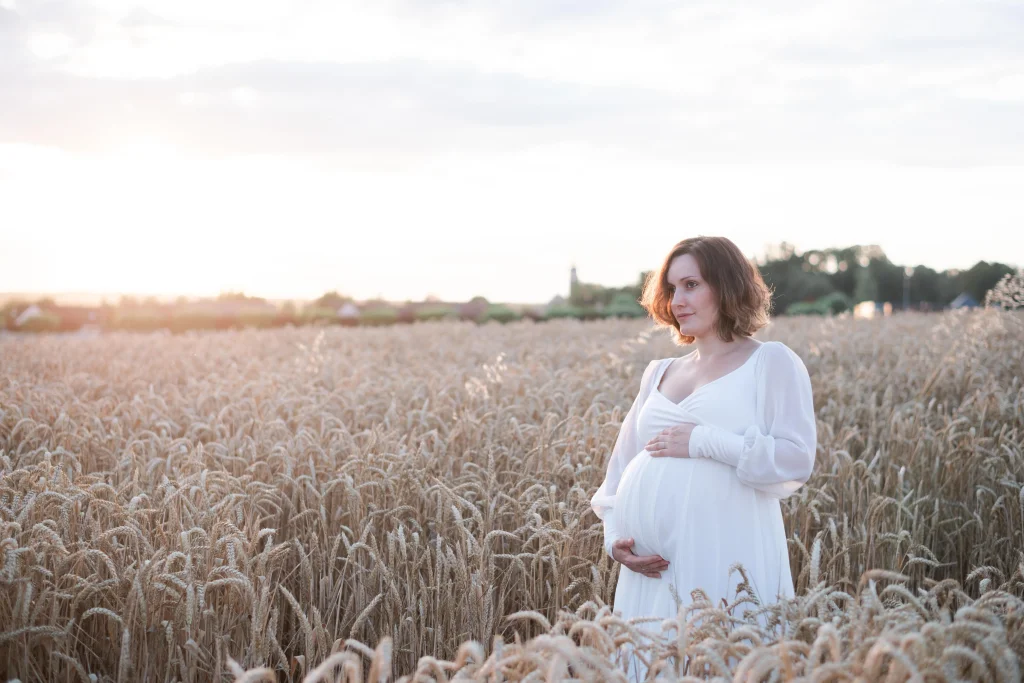 femme enceinte dans un champ de blé près de fontainebleau lors de son shooting grossesse