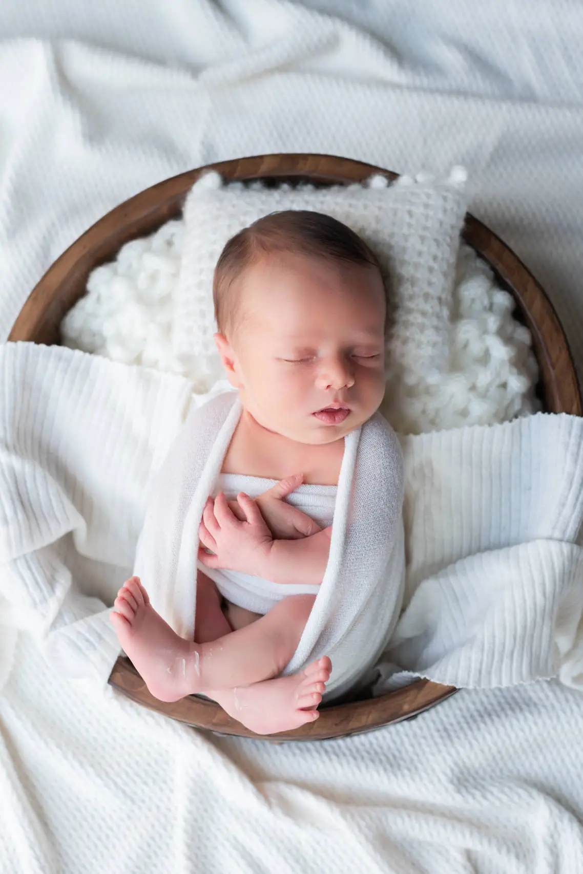 Portrait d'un nouveau-né emmailloté lors de sa séance photo de naissance à domicile près de Melun