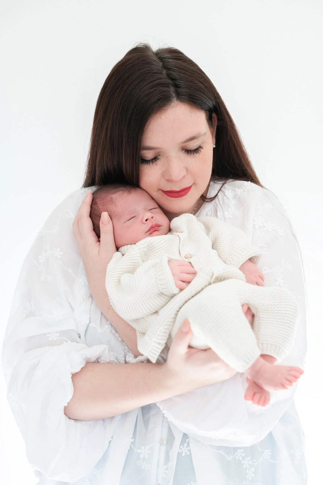 Portrait d'un nouveau-né dans les bras de sa maman lors d'une séance photo de naissance à domicile près de Melun