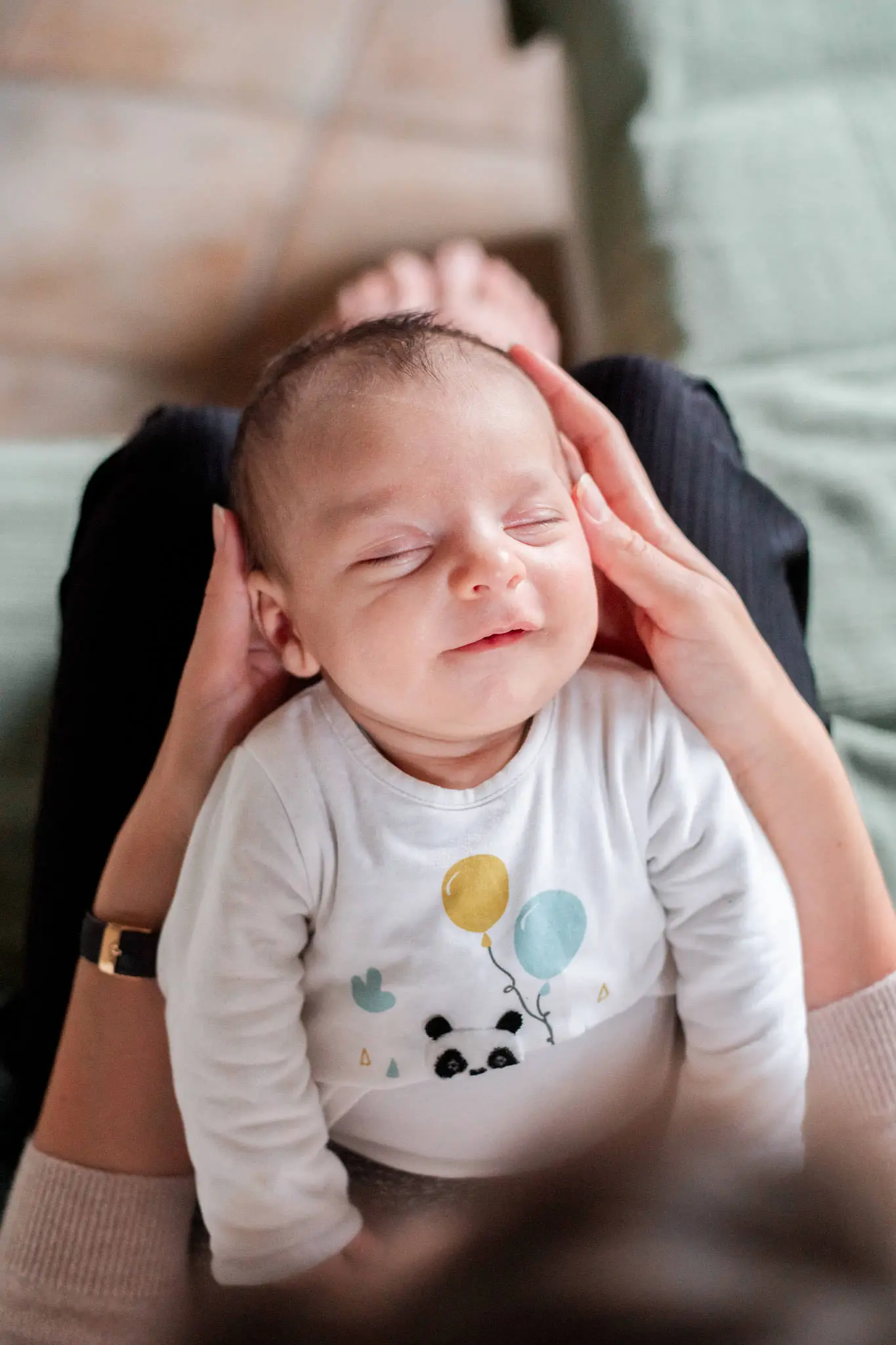 Photo d'un bébé qui fait un sourire de l'ange après la tétée, lors d'une séance photo à domicile à côté de Melun
